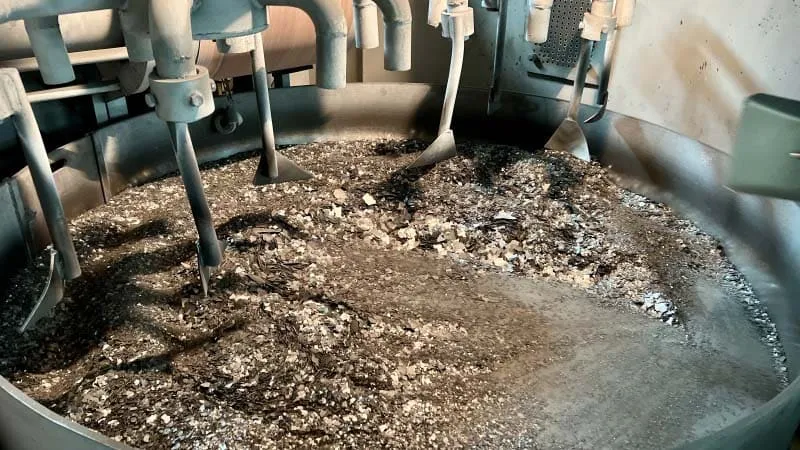 Melting strips of magnet’s raw material, showing the initial stage of the manufacturing process where raw materials are melted and formed into strips.